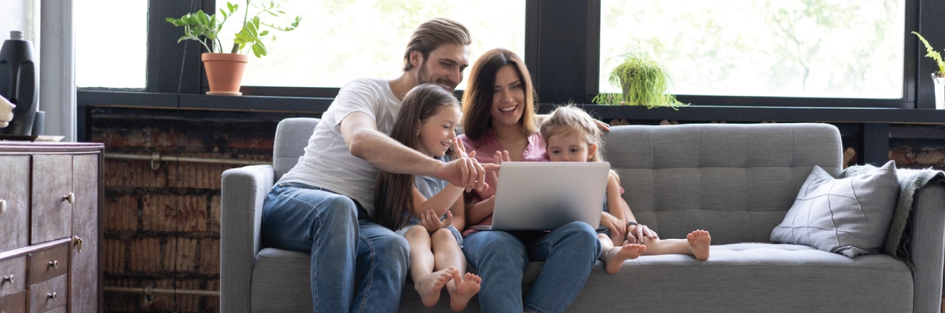 Family sitting on the couch researching accident and critical illness insurance