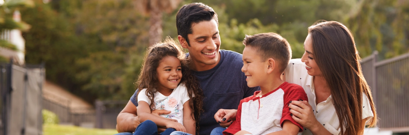 Family smiling outside in the grass