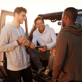 three men sitting outside talking smiling