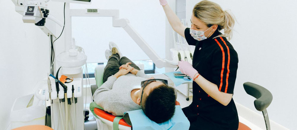 dental hygenist helping patient